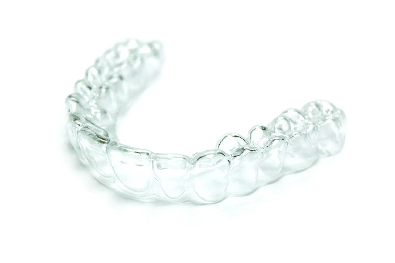 Clear removable aligner tray on a white background
